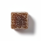 single sugar-coated dark brown cubed gummy overhead casting a light shadow isolated on white